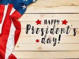American flag on the side with wooden background with text stating "Happy President's Day!"